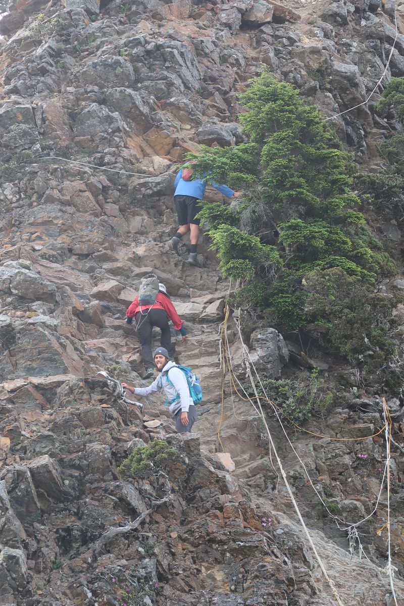 Wanderer klettern Felswend hoch